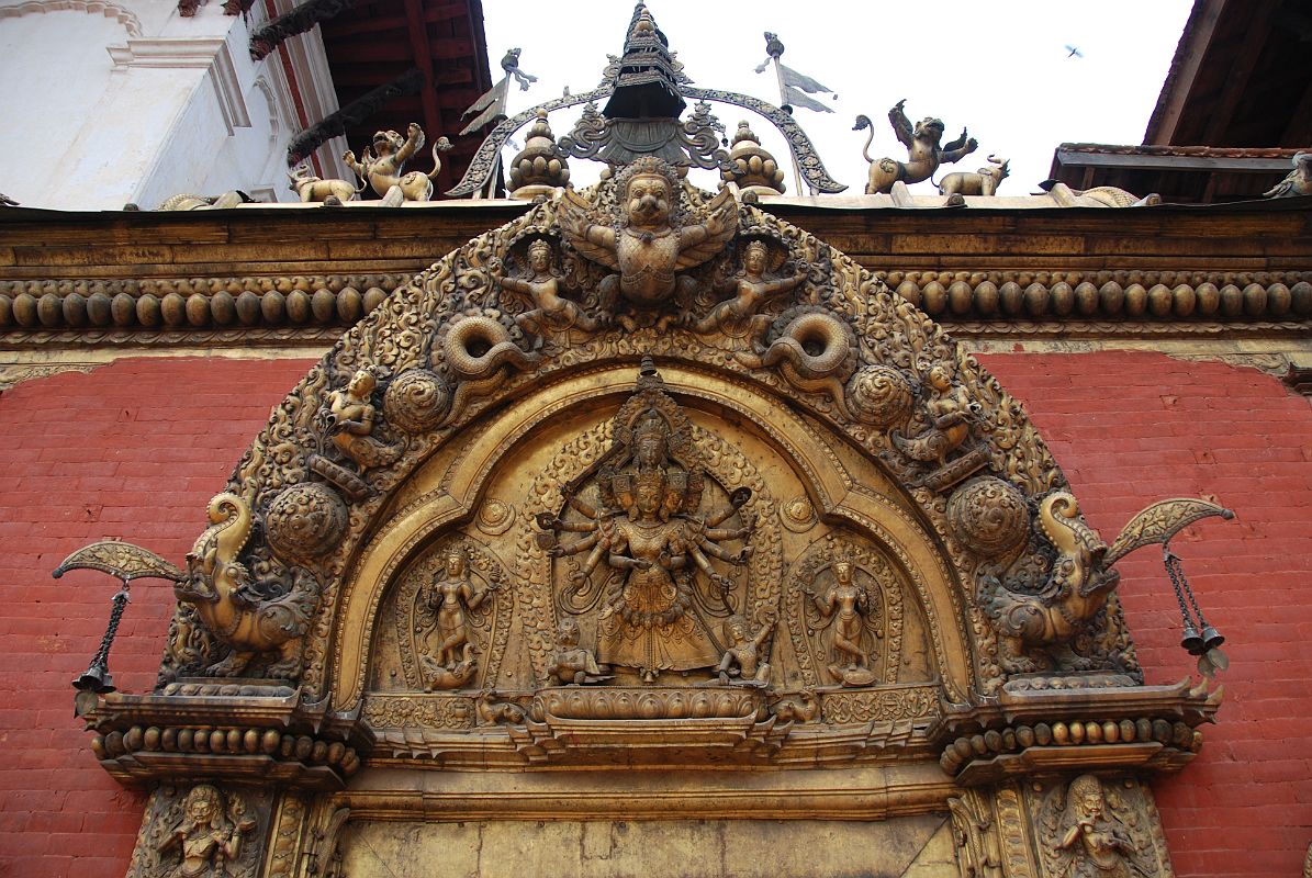 Kathmandu Bhaktapur 04-2 Bhaktapur Durbar Square Golden Gate Torana With Garuda And Taleju Bhawani A garuda tops the torana, disposing of a number of serpents, at the Golden Gate in Bhaktapurs Durbar Square. The four-headed and 10-armed figure of the goddess Taleju Bhawani is directly above the door.